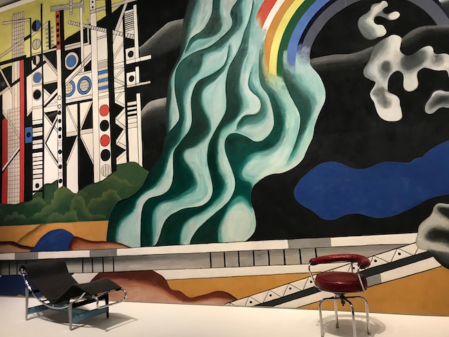 La chaise longue de charlotte Perriand, son fauteuil de bureau, devant une immense tapisserie de Fernand Léger introduisent l'exposition rétrospective que consacre la Fondation Vuitton à l'architecte d'intérieur. ©Rivaud/NAJA  